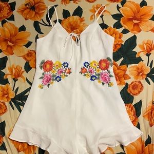 Brand new never worn white romper with flowers.